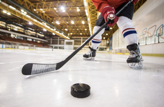 En hockeyspelare som har stannat med pucken framför klubban.